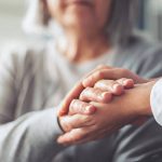 Hands holding old woman's hands